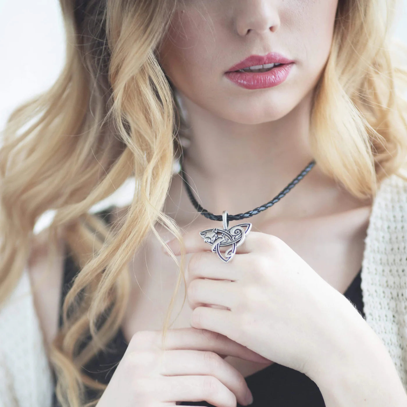 Blonde woman with celtic cat necklace displayed on her hands